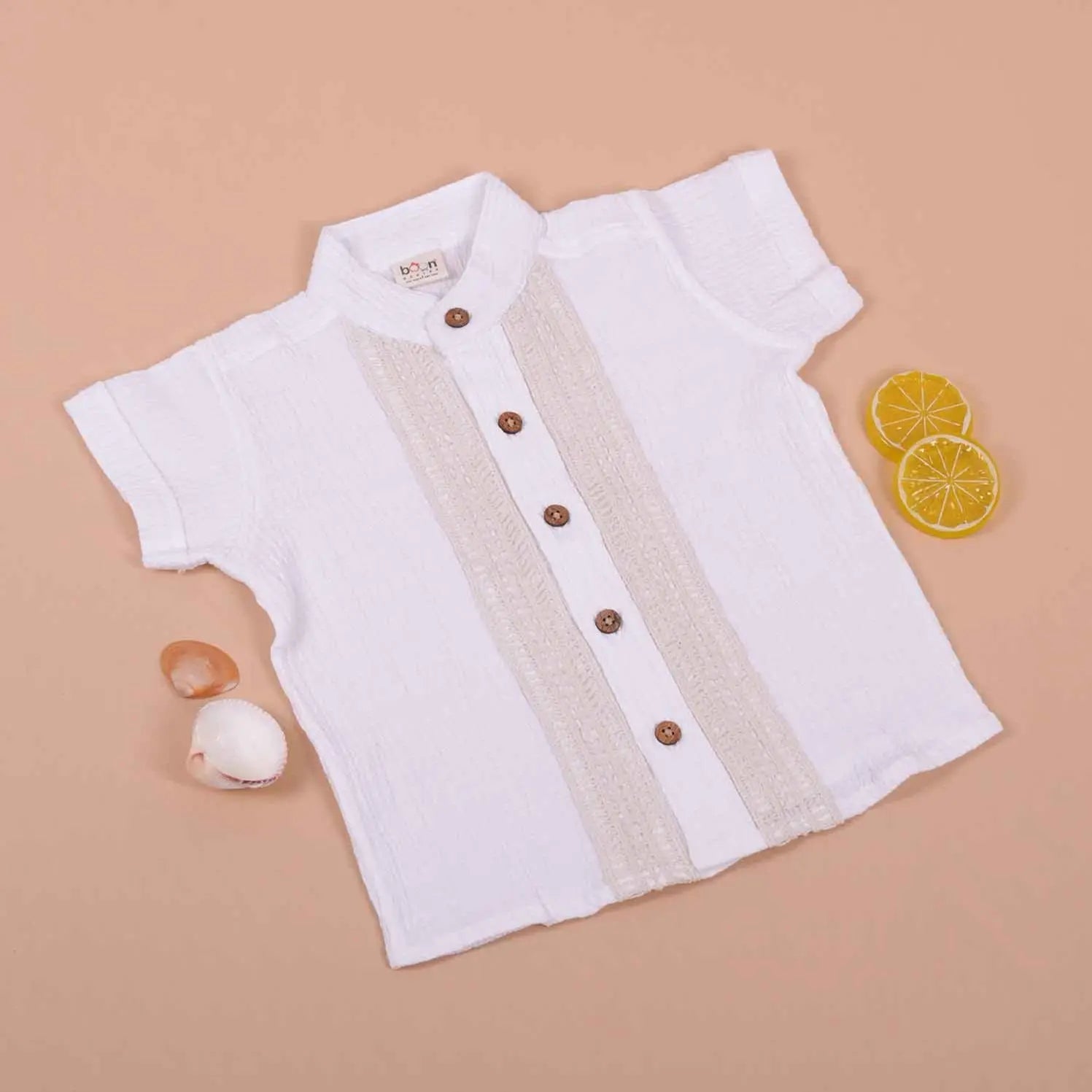 Boy's white cotton popcorn shirt with wooden buttons, solid design, by Boon Babies, suitable for ages 6 to 12 months.