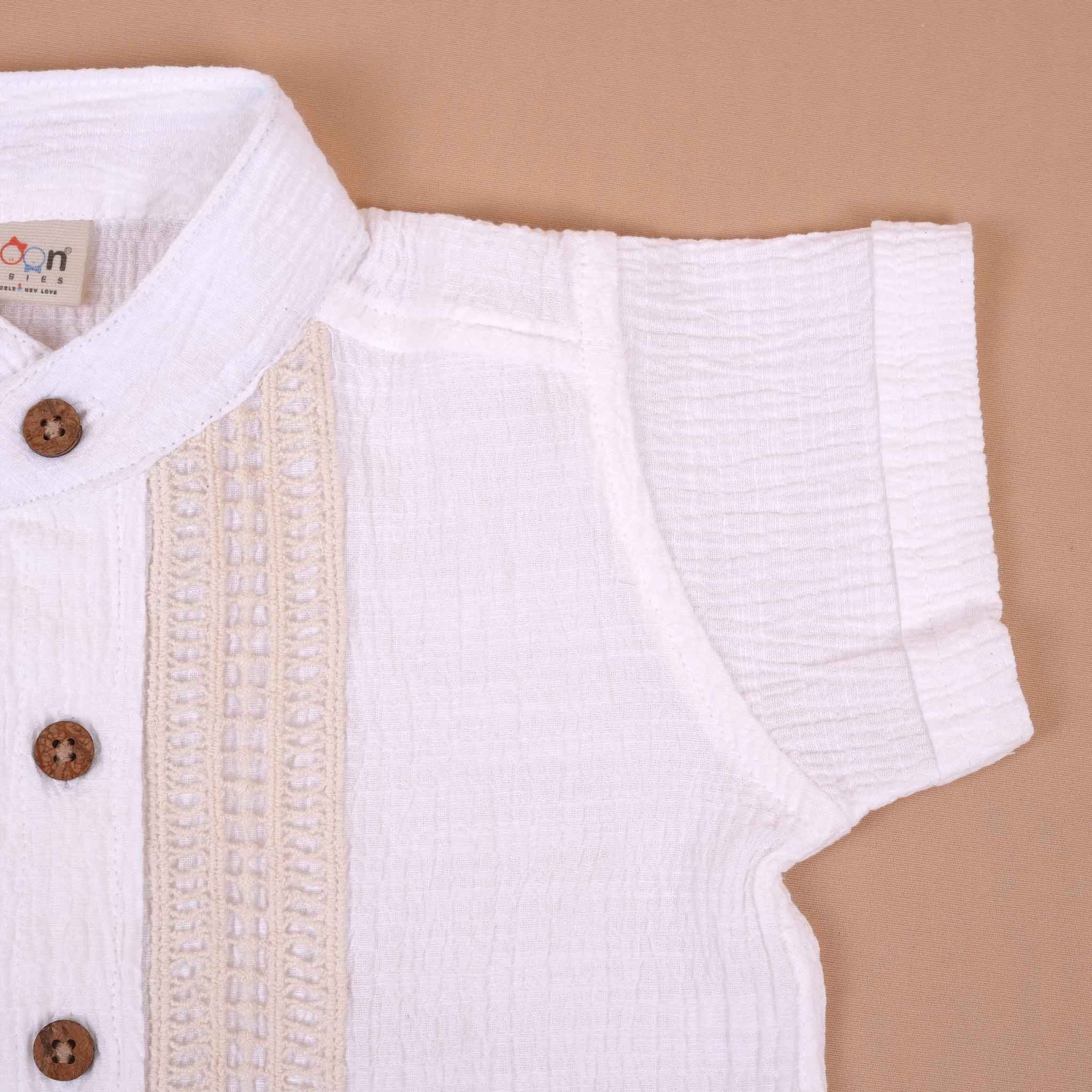 White cotton popcorn shirt for boys by Boon Babies, featuring wooden buttons and a classic solid design for infants aged 6-12 months.