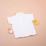 Boys white cotton popcorn shirt with wooden buttons, solid style, from Boon Babies, suitable for ages 6-12 months.