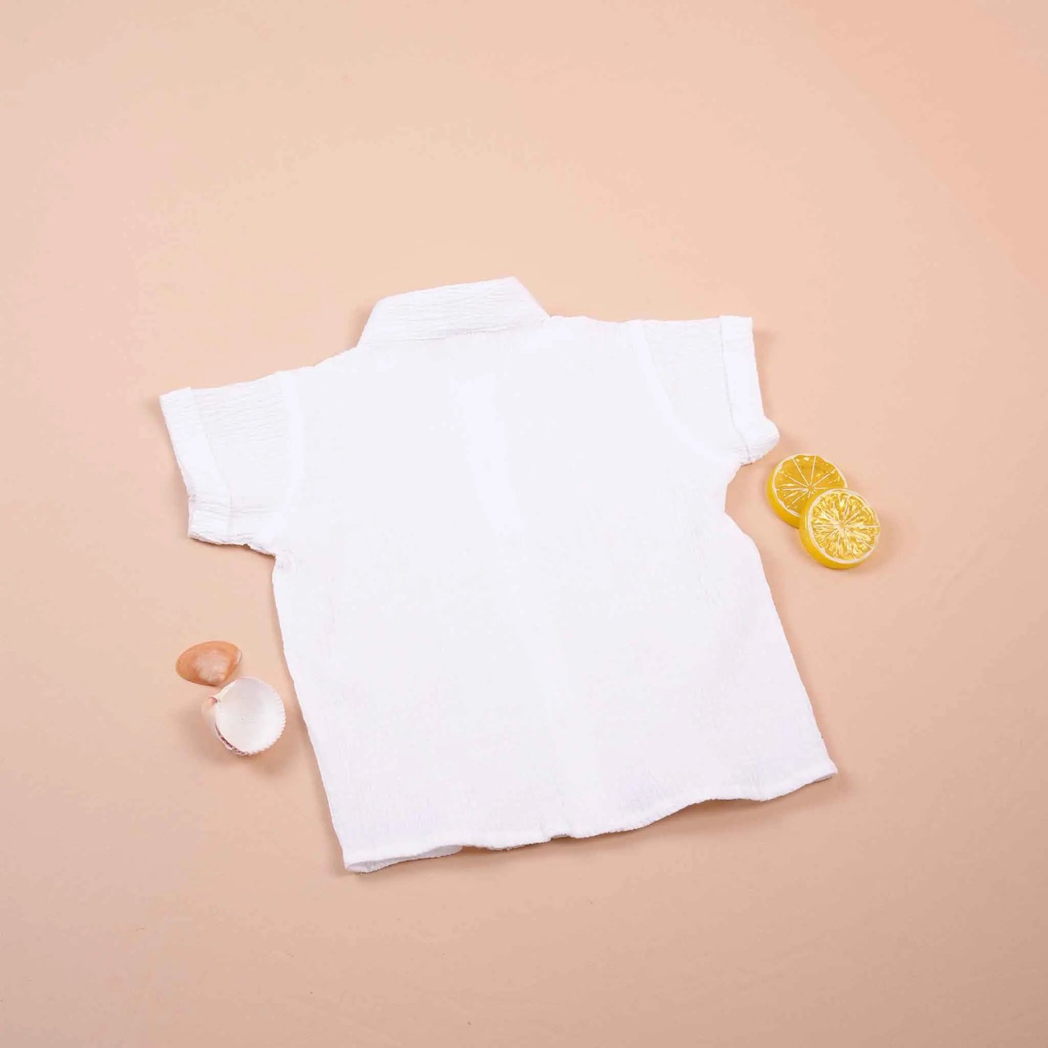 Boys white cotton popcorn shirt with wooden buttons, solid style, from Boon Babies, suitable for ages 6-12 months.