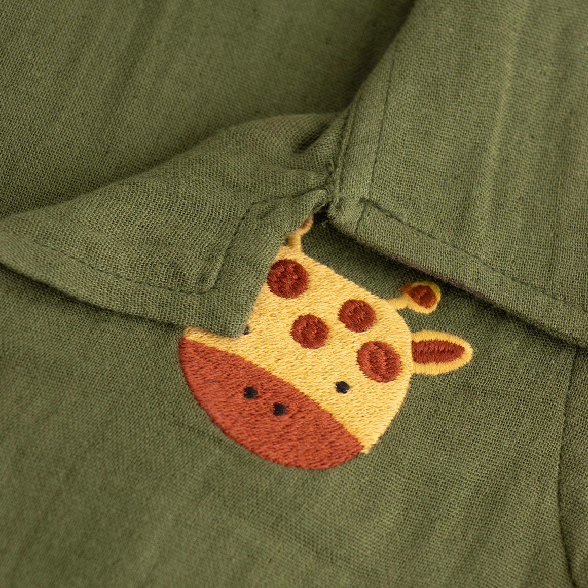 Dark olive green boys shirt and shorts set made of soft crinkled muslin, featuring a giraffe patch and wooden buttons – by Boon Babies in Coimbatore.
