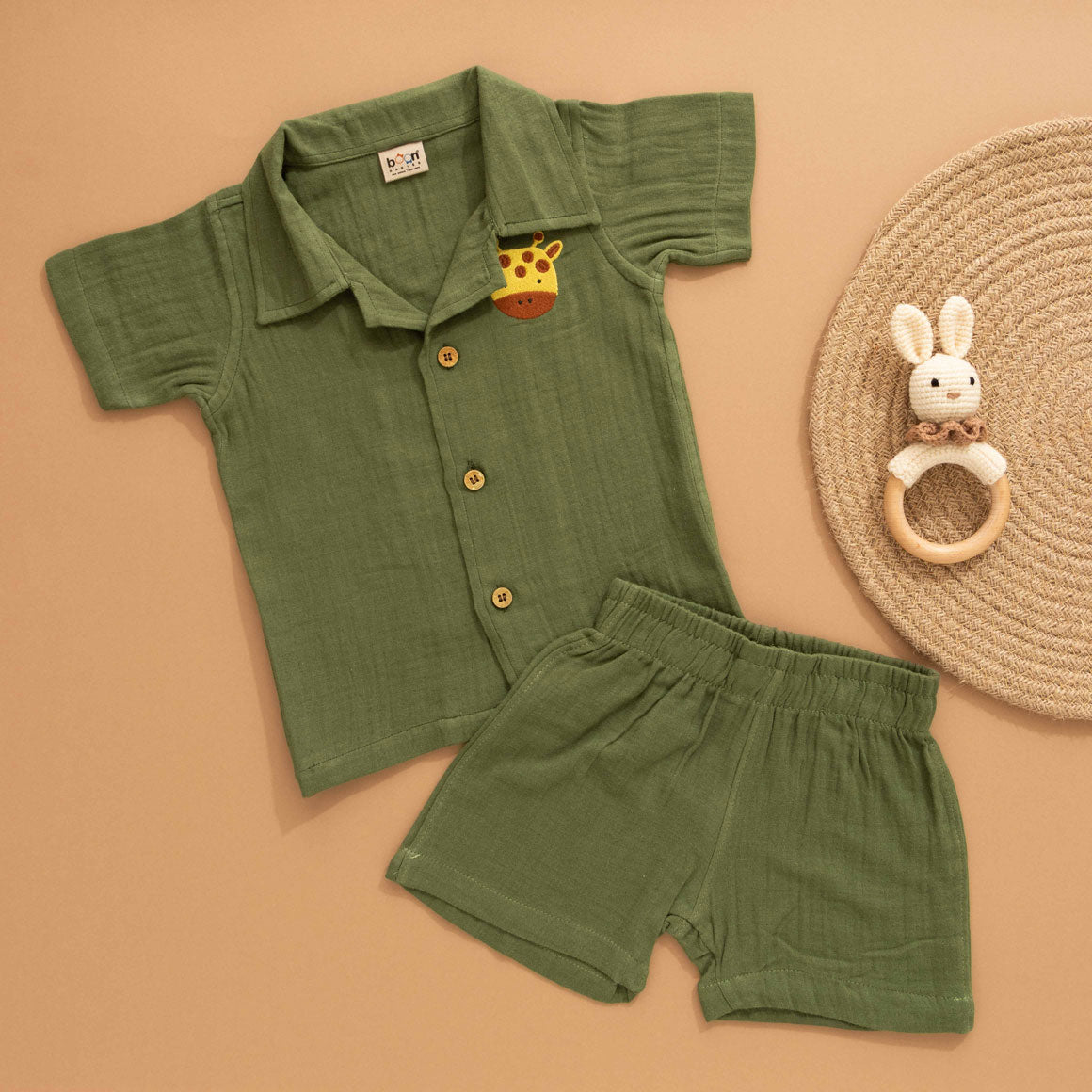 Dark olive green boys shirt and shorts set made of soft crinkled muslin, featuring a giraffe patch and wooden buttons – by Boon Babies in Coimbatore.
