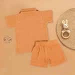 Orange crinkle muslin shirt and shorts set for boys with lion face embroidery, open collar, and elastic shorts – Boon Babies’ breathable summer wear from Coimbatore.
