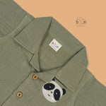 Panda face embroidered crinkle muslin shirt and shorts set in earthy green for boys, featuring an open collar and elastic shorts – from Boon Babies, Coimbatore.
