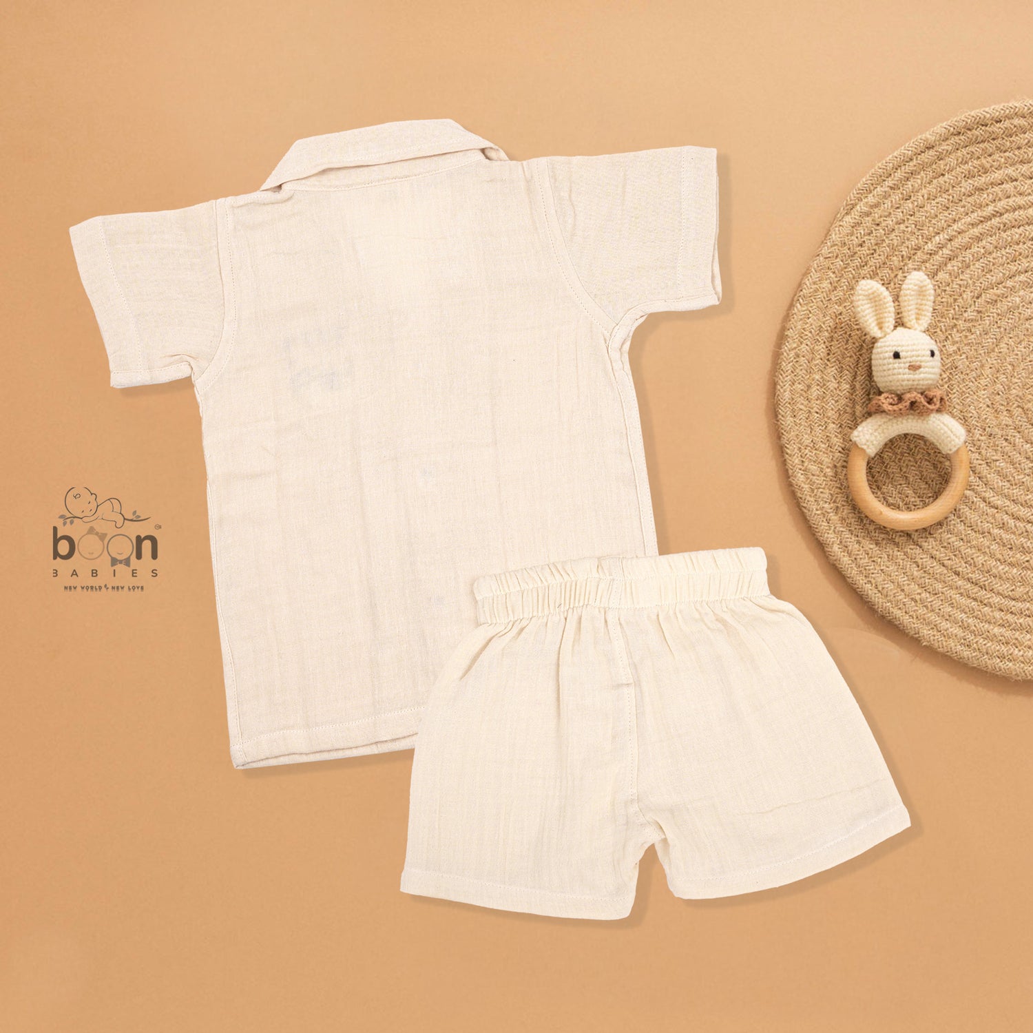 Cream crinkle muslin shirt and shorts set for boys featuring tiger face embroidery, open collar, and elastic shorts – from Boon Babies, Coimbatore.
