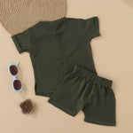 Dark olive green boys muslin co-ord with giraffe patch embroidery, round neck shirt with buttons, and elastic shorts – by Boon Babies, Coimbatore.
