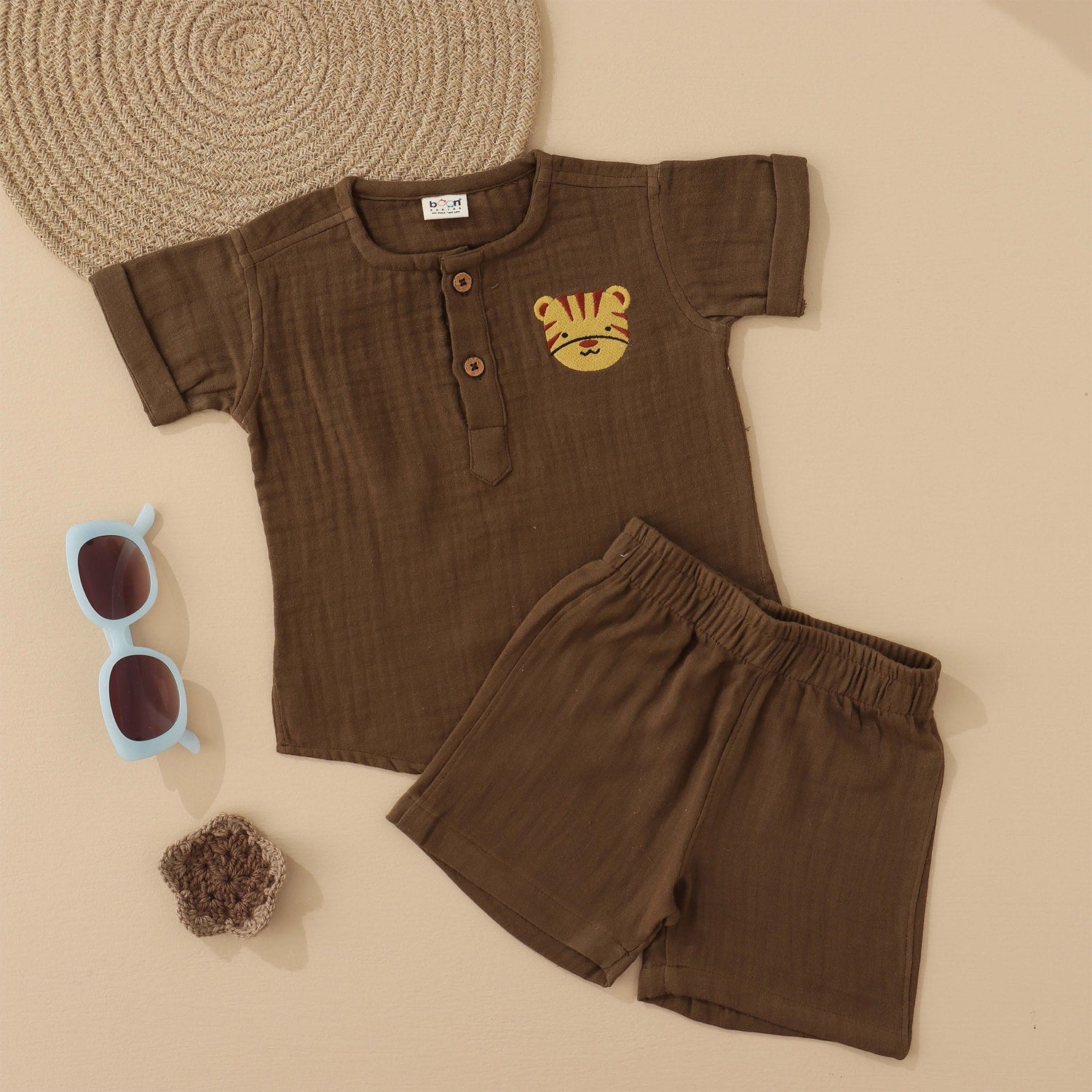 Olive green boys’ muslin shirt and shorts set with tiger face embroidery, wooden buttons, and elastic shorts – soft summer outfit by Boon Babies, Coimbatore.
