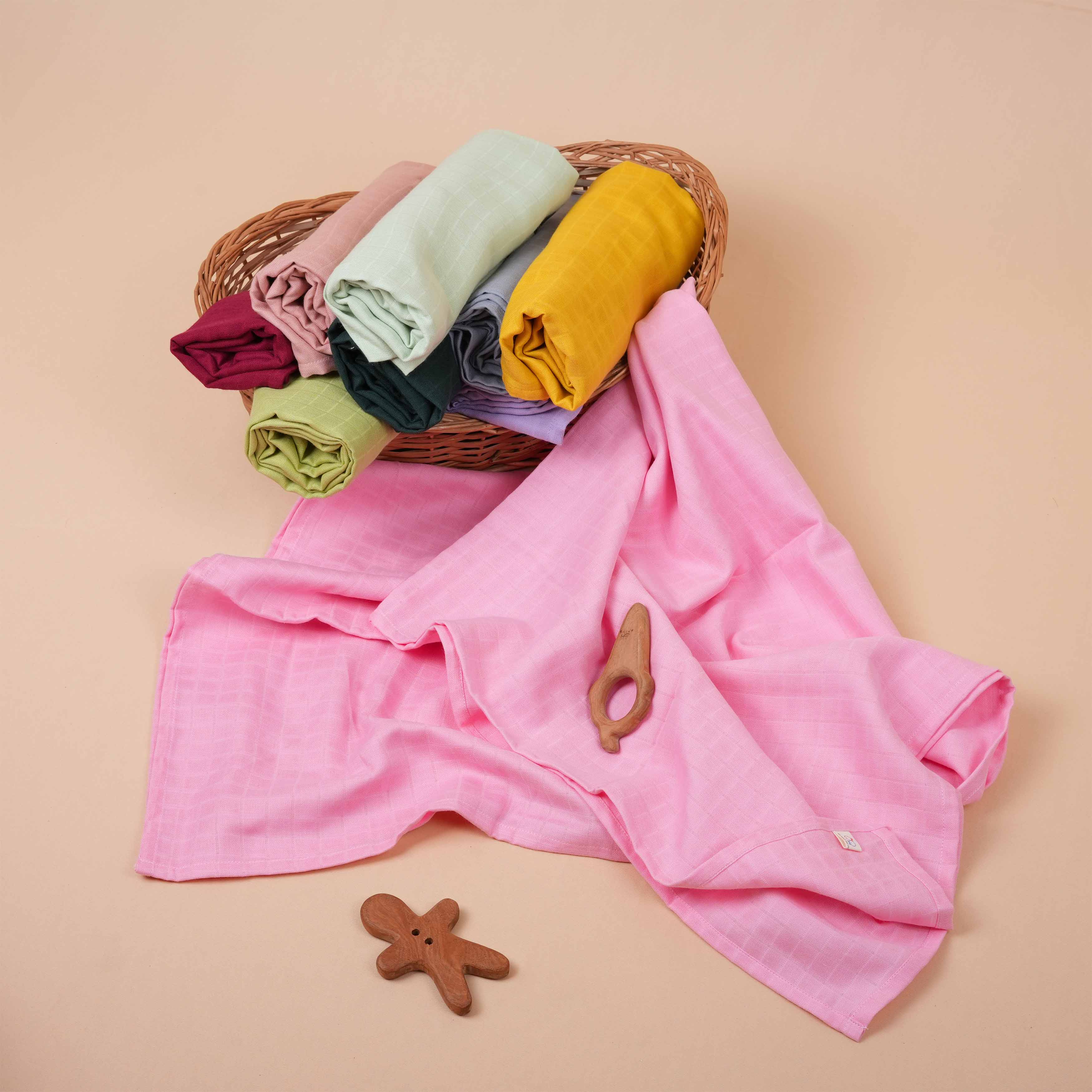 Pink muslin baby swaddle by Boon Babies, ultra-soft solid pink swaddle blanket for newborns, gentle and breathable fabric.