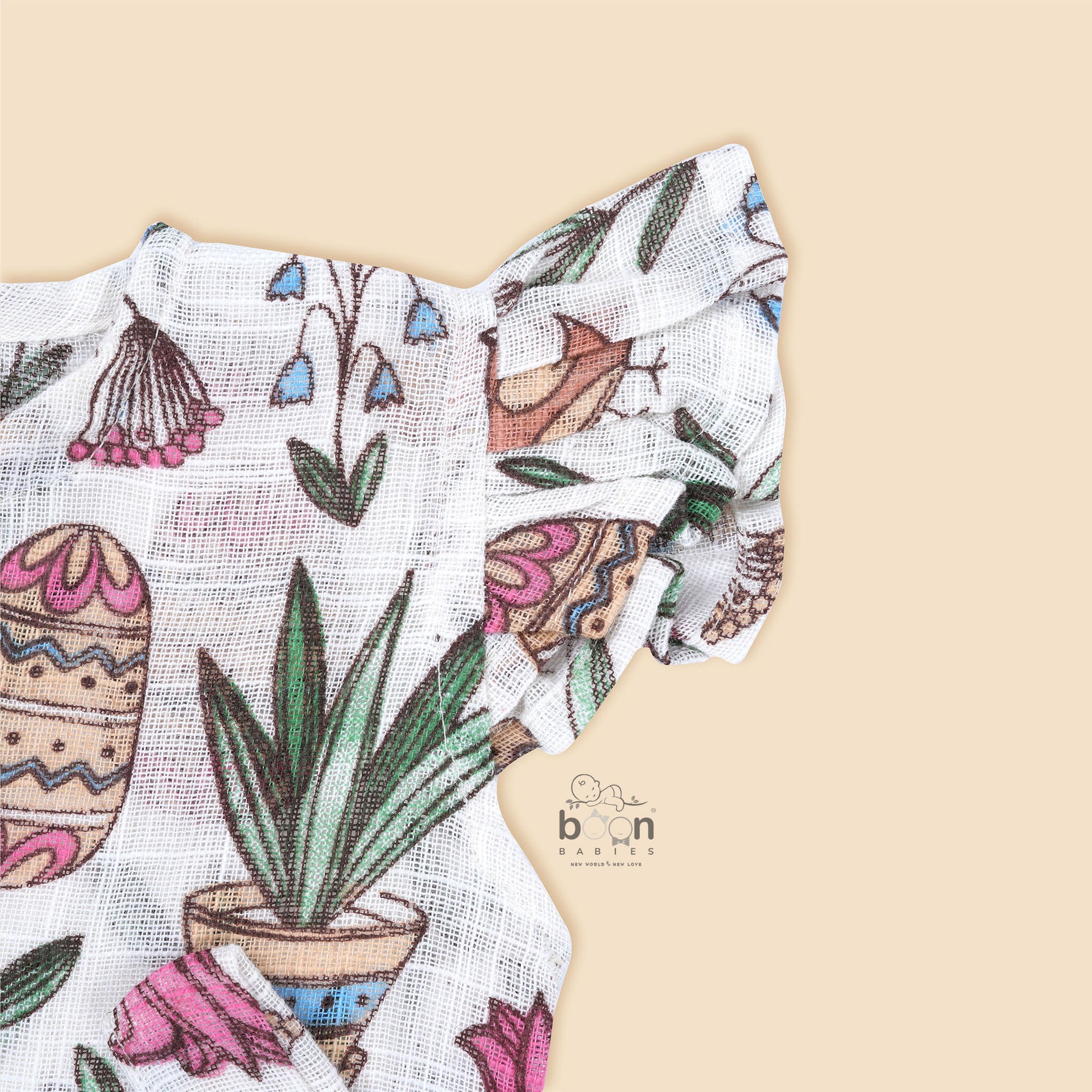 Cotton baby romper with colorful botanical and bird print, flutter sleeves, side bows, and front snap buttons – from Boon Babies, Coimbatore.
