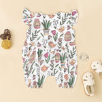 Cotton baby romper with colorful botanical and bird print, flutter sleeves, side bows, and front snap buttons – from Boon Babies, Coimbatore.
