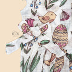 Cotton baby romper with colorful botanical and bird print, flutter sleeves, side bows, and front snap buttons – from Boon Babies, Coimbatore.

