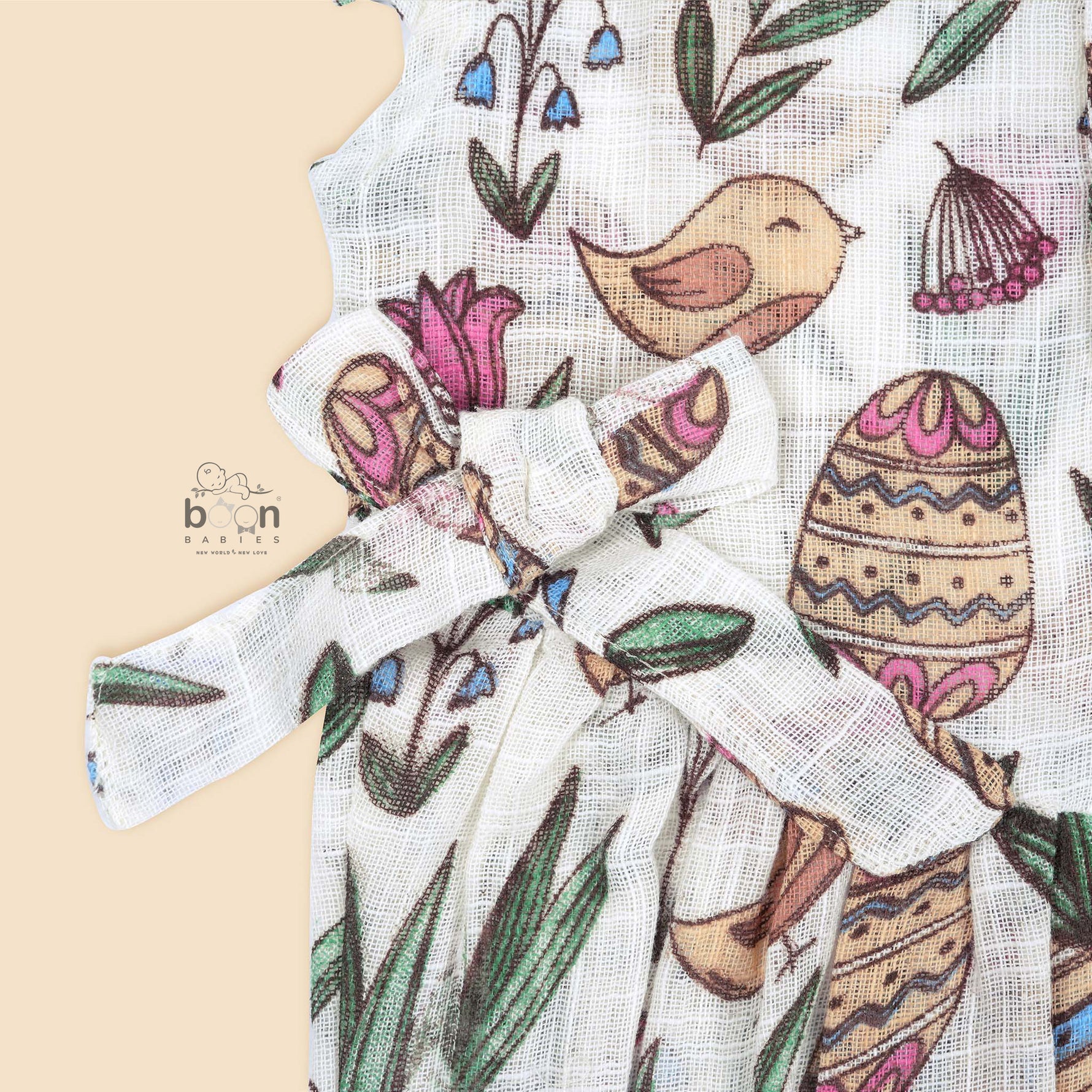 Cotton baby romper with colorful botanical and bird print, flutter sleeves, side bows, and front snap buttons – from Boon Babies, Coimbatore.
