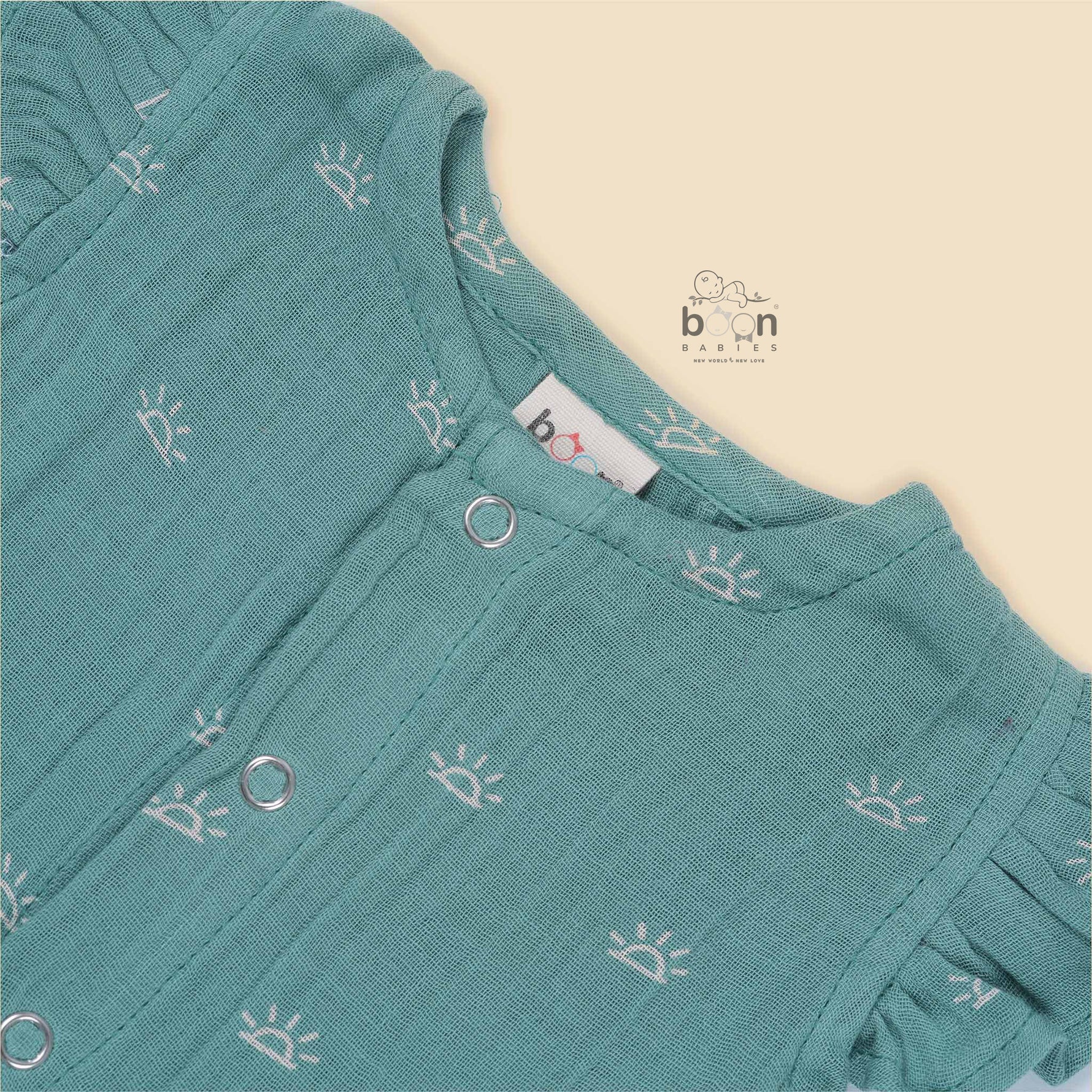 Crinkled muslin baby romper in dusty green with white sun print and flutter sleeves – perfect for 0 to 12 months, from Boon Babies baby cloths collection in Coimbatore.