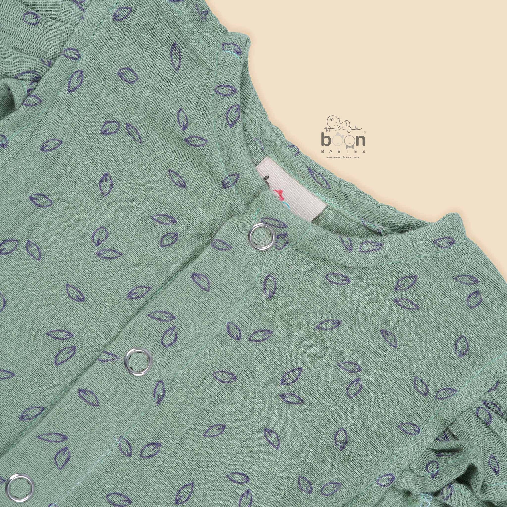 Mint green baby romper in crinkled muslin with leafy print and flutter sleeves, designed for newborns aged 0 to 12 months – Boon Babies Coimbatore collection.