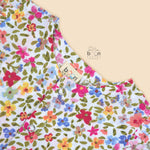 Baby girl romper in soft crinkled muslin with multicolor floral print, flutter sleeves, and side bows – ideal for babies aged 0–12 months by Boon Babies, Coimbatore.