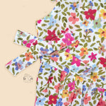 Baby girl romper in soft crinkled muslin with multicolor floral print, flutter sleeves, and side bows – ideal for babies aged 0–12 months by Boon Babies, Coimbatore.