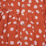Rust orange baby romper with white polka dots, flutter sleeves, and side bows – made from soft crinkled muslin for babies aged 0–12 months by Boon Babies, Coimbatore.