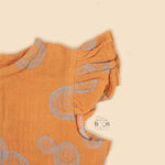 Crinkled muslin baby romper in rust orange with spiral print, flutter sleeves, and snap-down front – soft summer outfit for babies from Boon Babies, Coimbatore.