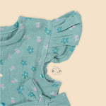 Teal blue baby romper with white floral prints, flutter sleeves, and side bows made from breathable crinkled muslin – designed for babies aged 0–12 months by Boon Babies, Coimbatore.