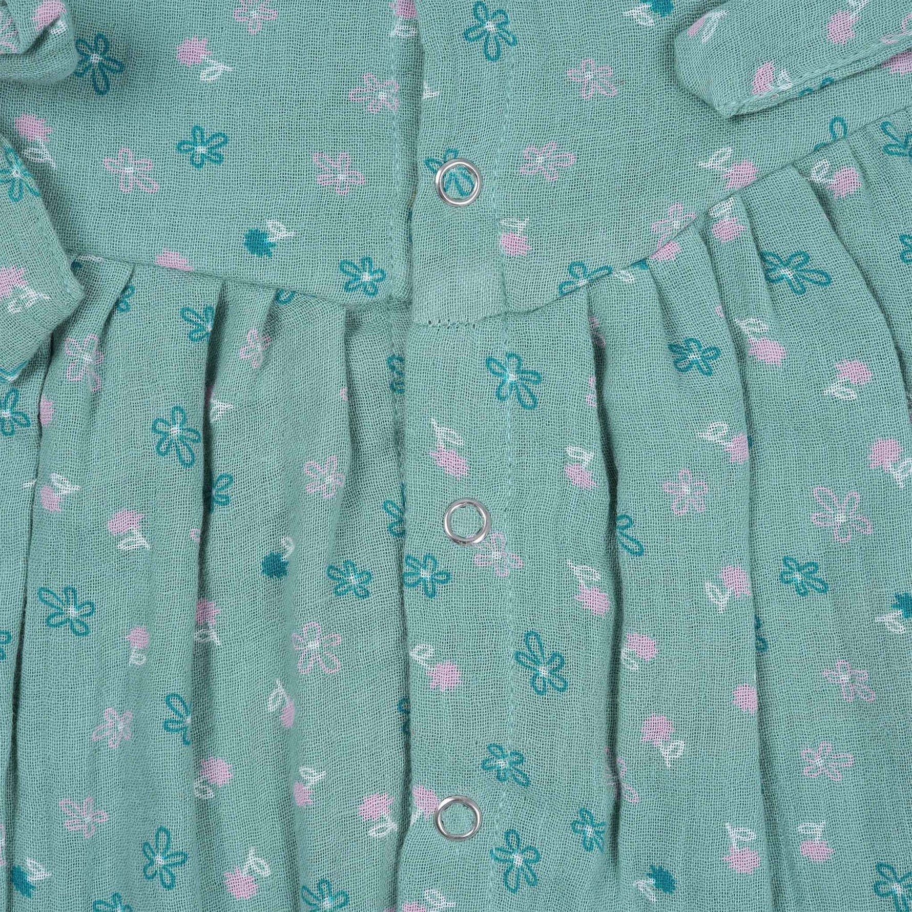 Teal blue baby romper with white floral prints, flutter sleeves, and side bows made from breathable crinkled muslin – designed for babies aged 0–12 months by Boon Babies, Coimbatore.