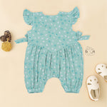 Teal blue baby romper with white floral prints, flutter sleeves, and side bows made from breathable crinkled muslin – designed for babies aged 0–12 months by Boon Babies, Coimbatore.