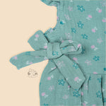 Teal blue baby romper with white floral prints, flutter sleeves, and side bows made from breathable crinkled muslin – designed for babies aged 0–12 months by Boon Babies, Coimbatore.