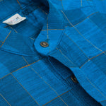 Blue checked silk shirt with Chinese collar and white dhoti with gold border – boys traditional outfit from Boon Babies, styled flatlay.
