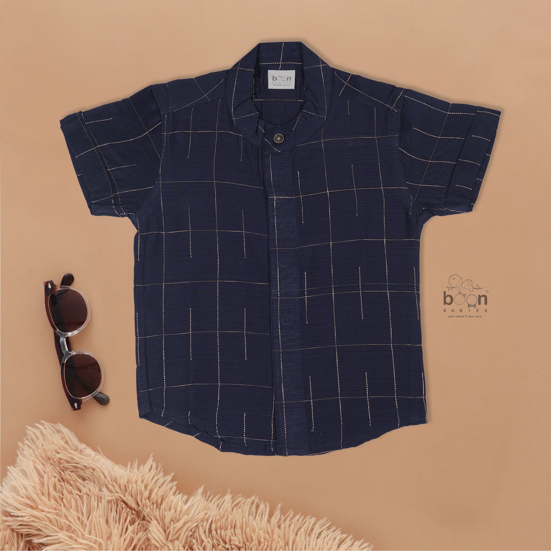 Navy blue checked silk shirt with Chinese collar and white dhoti with gold border – traditional South Indian festive outfit for boys by Boon Babies.
