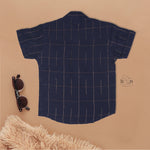 Navy blue checked silk shirt with Chinese collar and white dhoti with gold border – traditional South Indian festive outfit for boys by Boon Babies.
