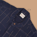 Navy blue checked silk shirt with Chinese collar and white dhoti with gold border – traditional South Indian festive outfit for boys by Boon Babies.
