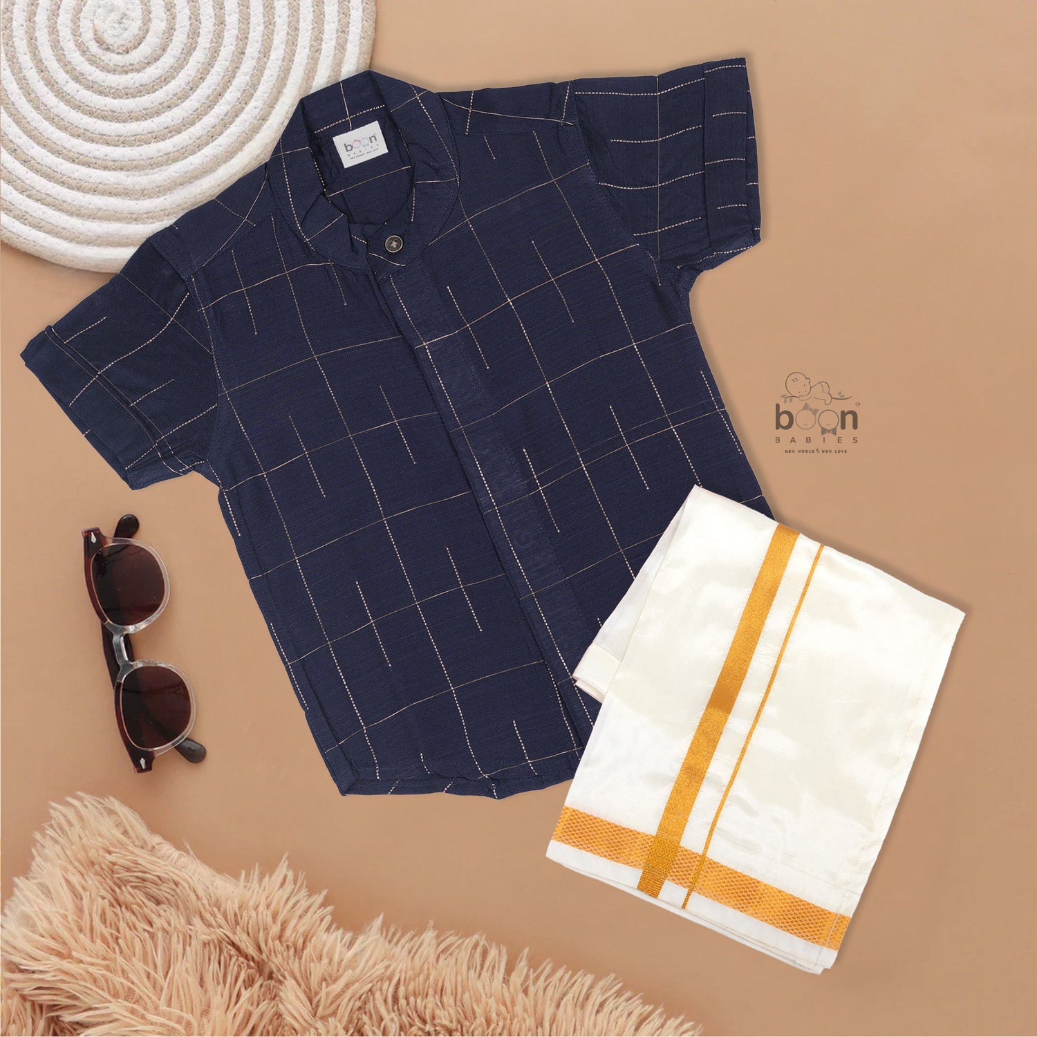 Navy blue checked silk shirt with Chinese collar and white dhoti with gold border – traditional South Indian festive outfit for boys by Boon Babies.
