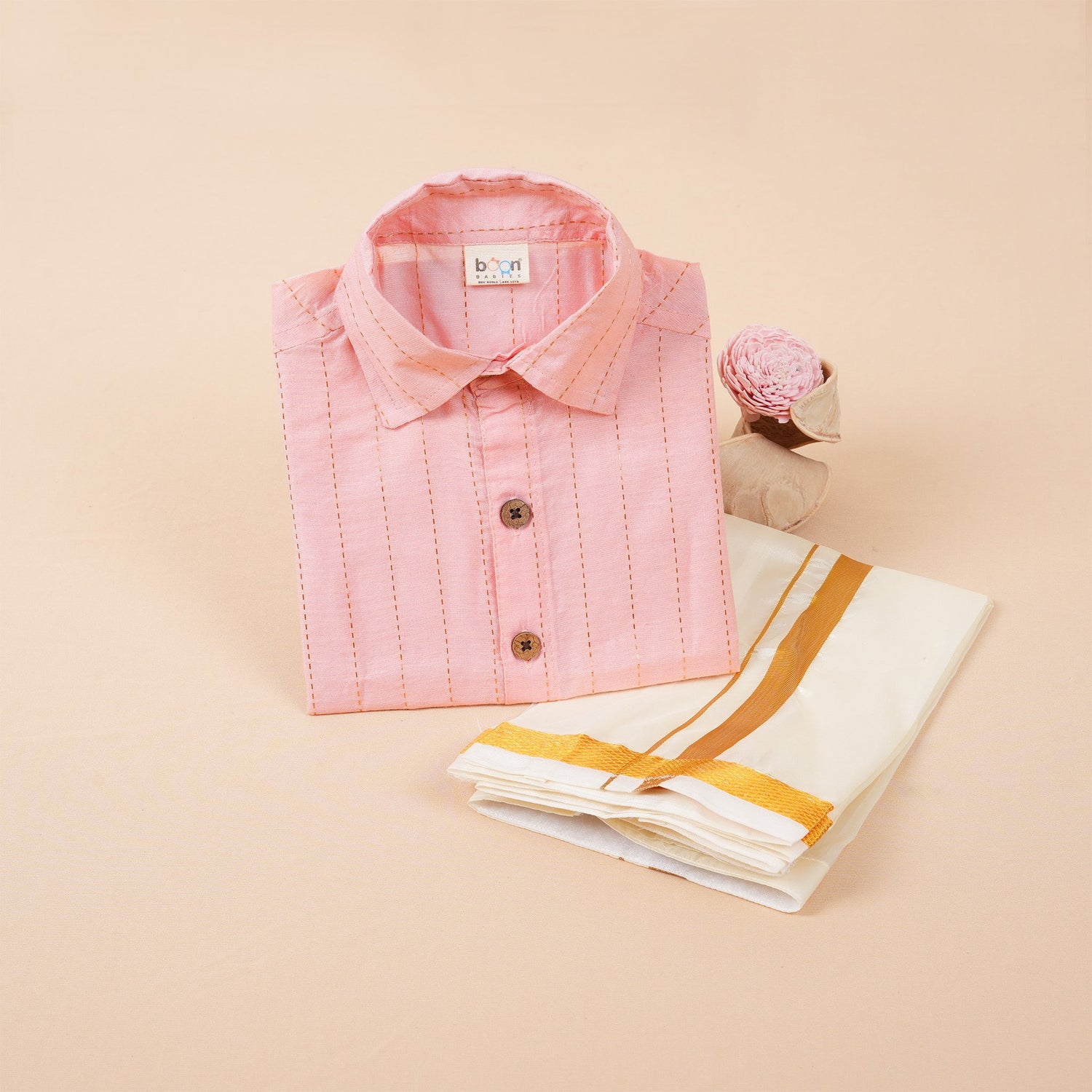Peach pink silk shirt with gold lines and white pattu dhoti with golden border – boys’ traditional wear set from Boon Babies.
