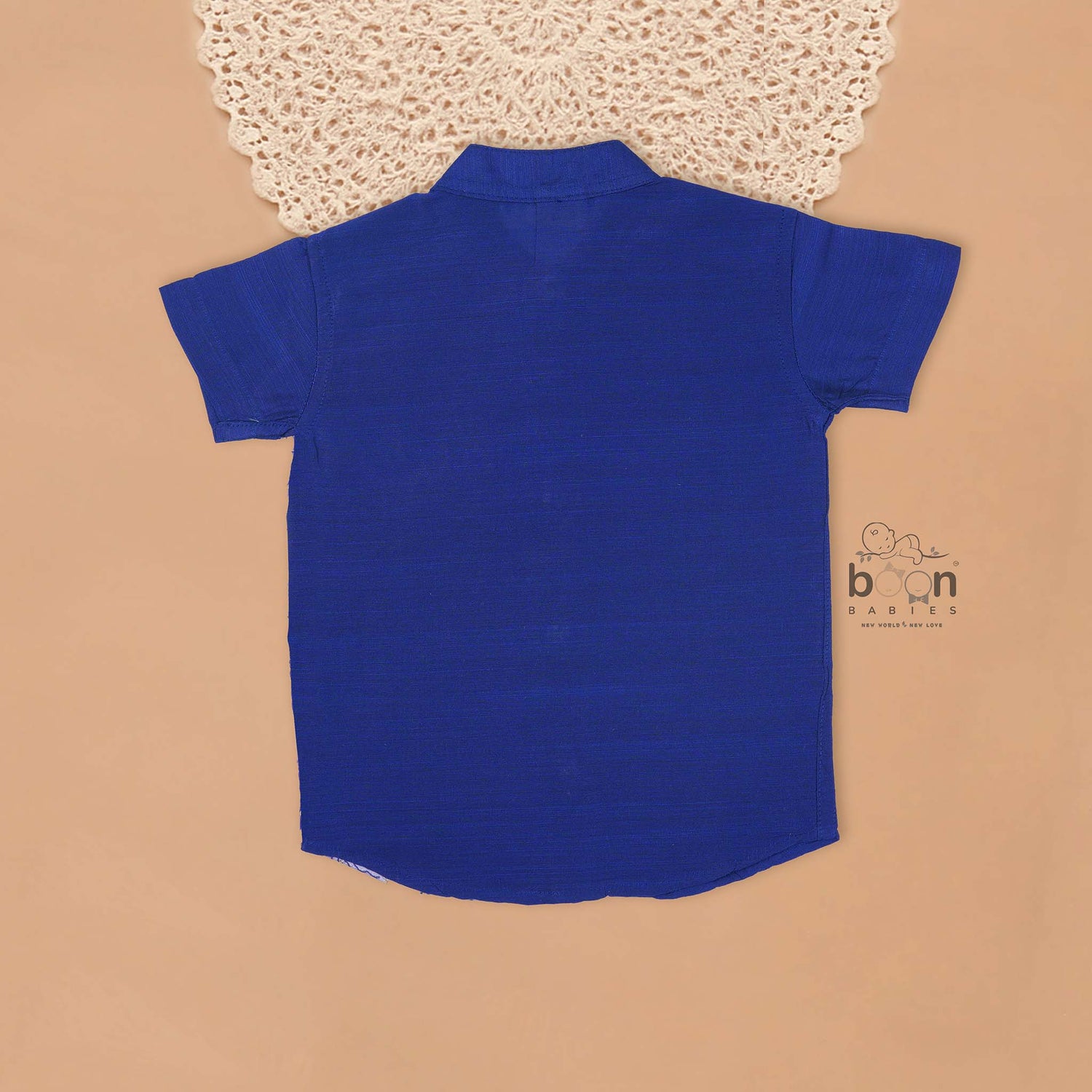 Royal blue silk panel shirt with floral embroidery paired with white pattu dhoti featuring a gold border – traditional festive outfit for boys by Boon Babies.
