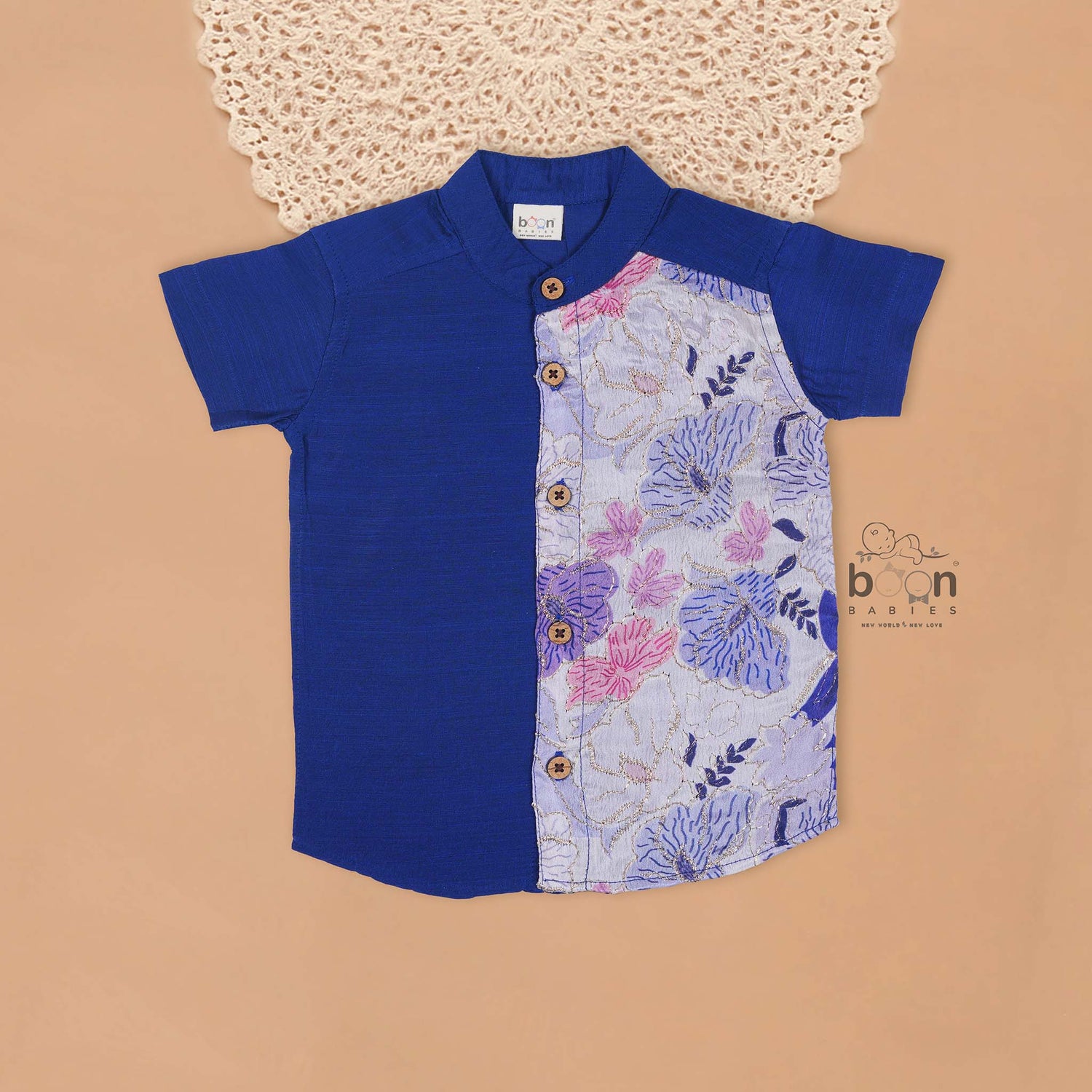 Royal blue silk panel shirt with floral embroidery paired with white pattu dhoti featuring a gold border – traditional festive outfit for boys by Boon Babies.
