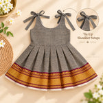 Charcoal grey Mangalagiri cotton baby girl frock front view with tie-up shoulder straps and pleated skirt