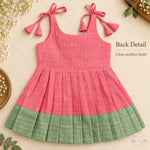 Coral pink tissue silk cotton baby girl knot frock back view with shoulder tie fastening and sage green border