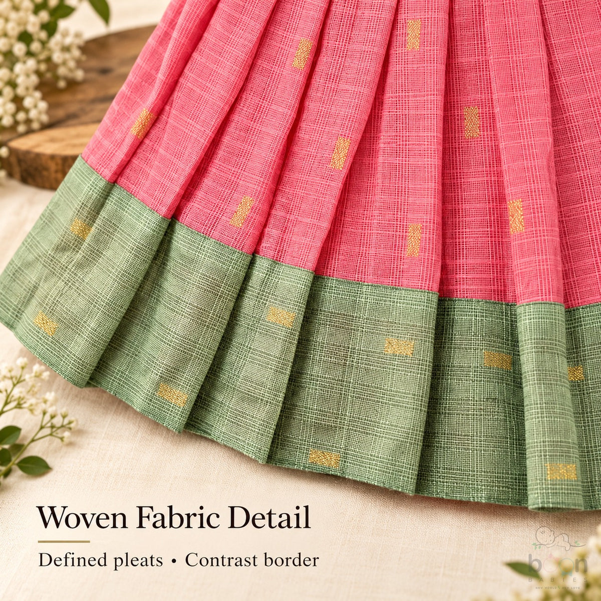 Woven tissue silk cotton texture, defined pleats and sage green contrast border on coral pink baby girl knot frock