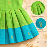Pleated silhouette and textured tissue silk cotton detail on green baby girl knot frock with turquoise border