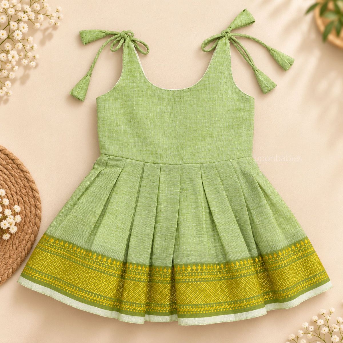 Pastel green Mangalagiri cotton baby girl frock front view with shoulder ties, pleated skirt and woven border